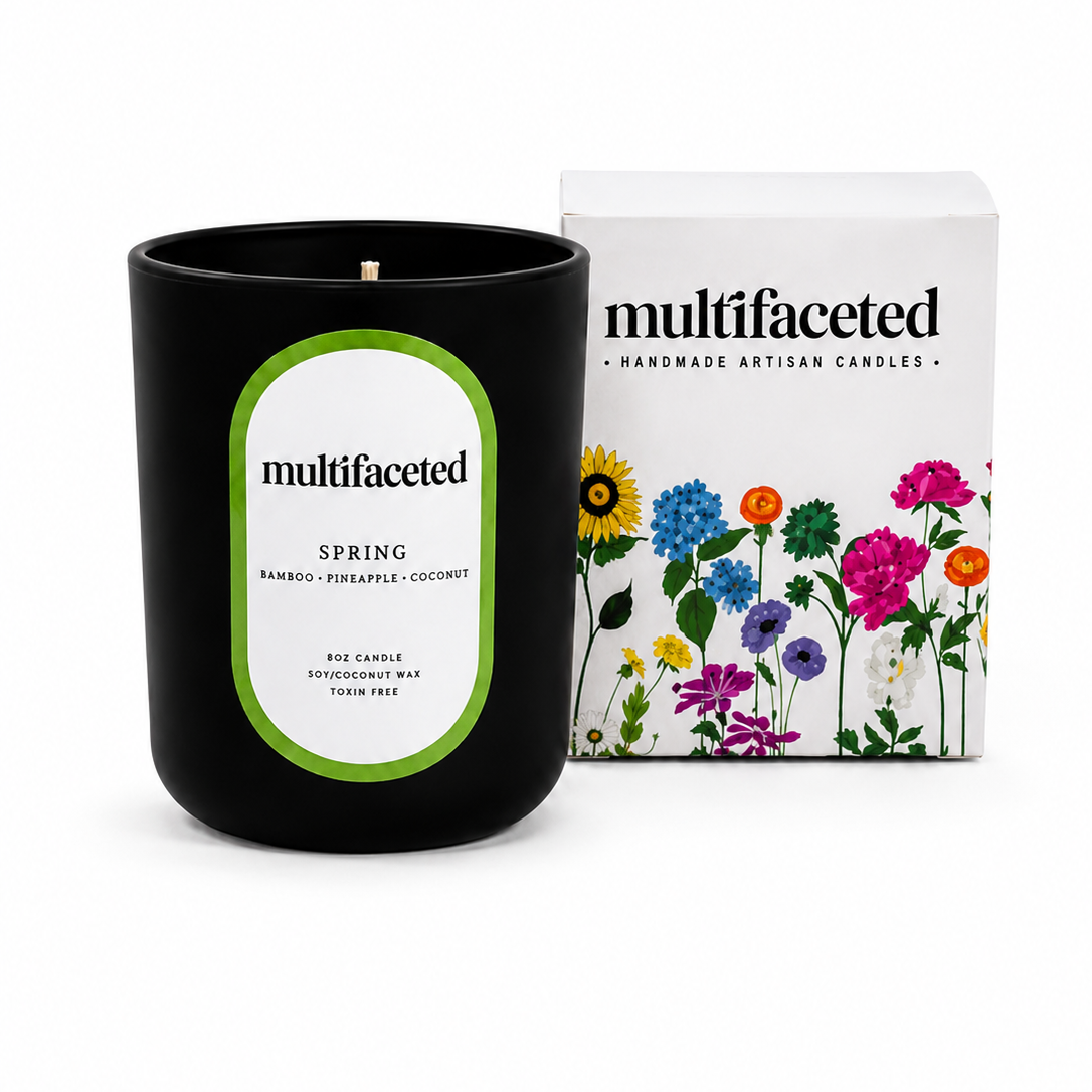 Black candle with green label and floral packaging on a white background