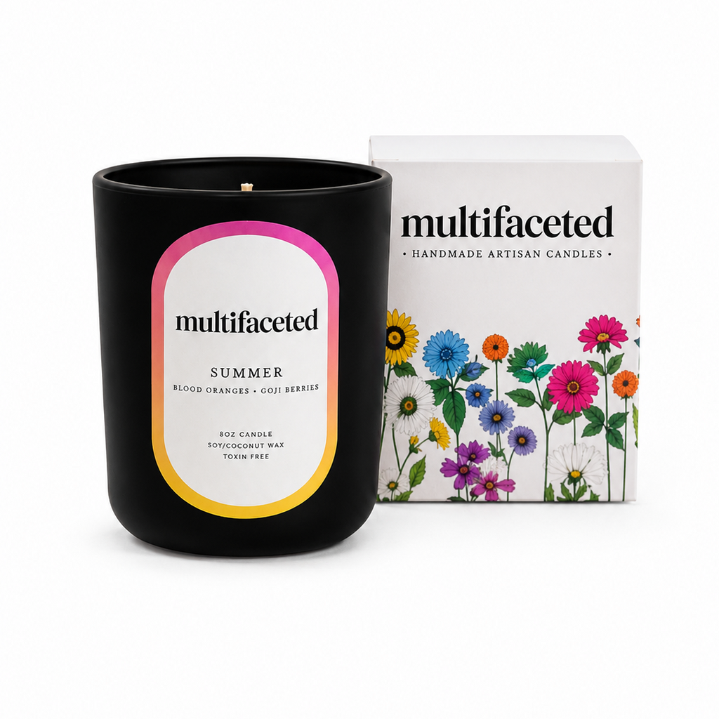 Black candle with 'multifaceted' label and floral packaging on a white background