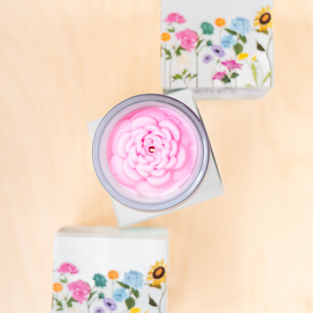 Candle with floral packaging on a beige background