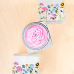 Candle with floral packaging on a beige background